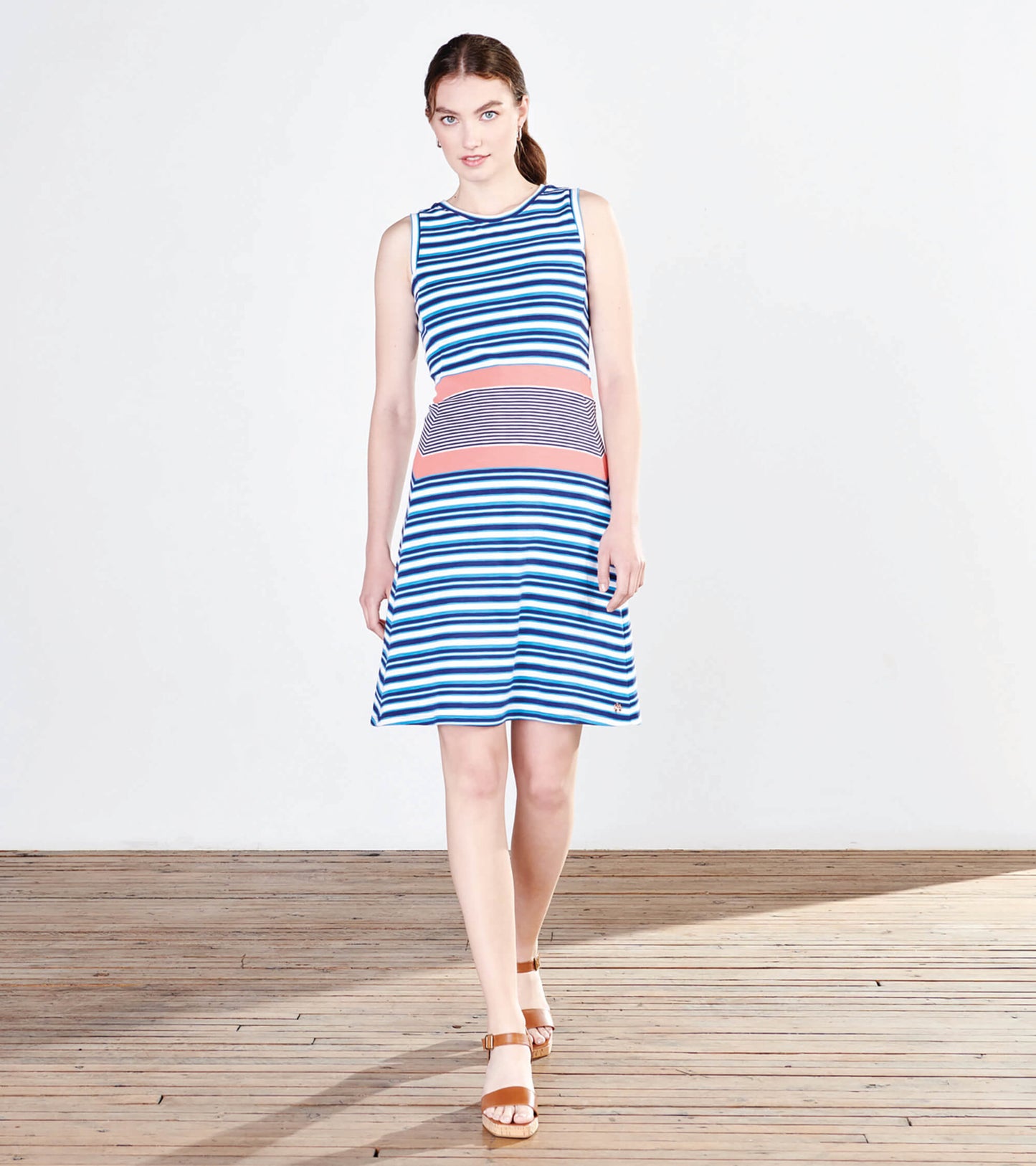 Sleeveless dress featuring blue and white stripes with a coral and gray striped waist, flared skirt silhouette.