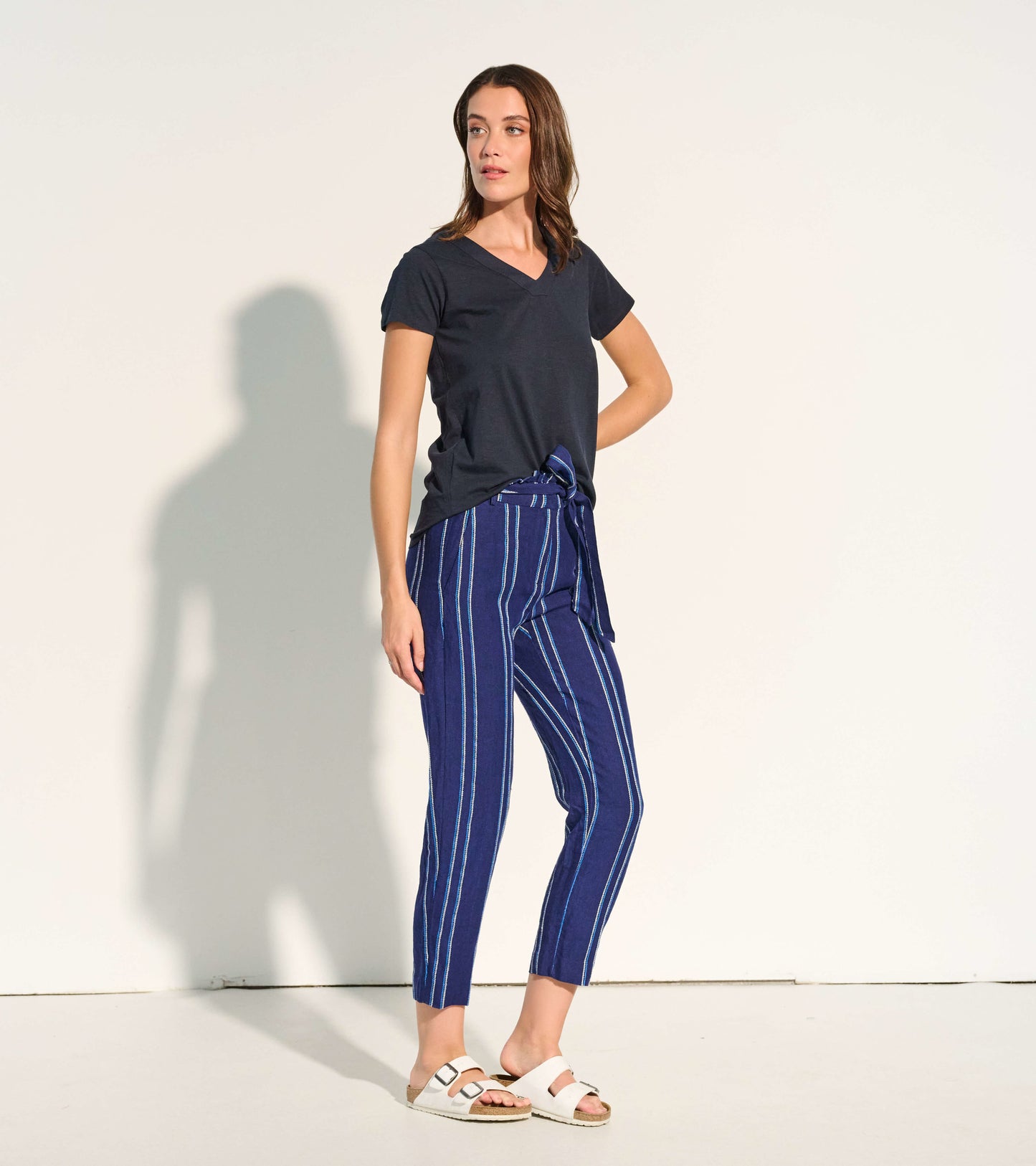 Navy paper bag pants with blue and white stripes, featuring a tie waist and cropped length, styled with a dark top.