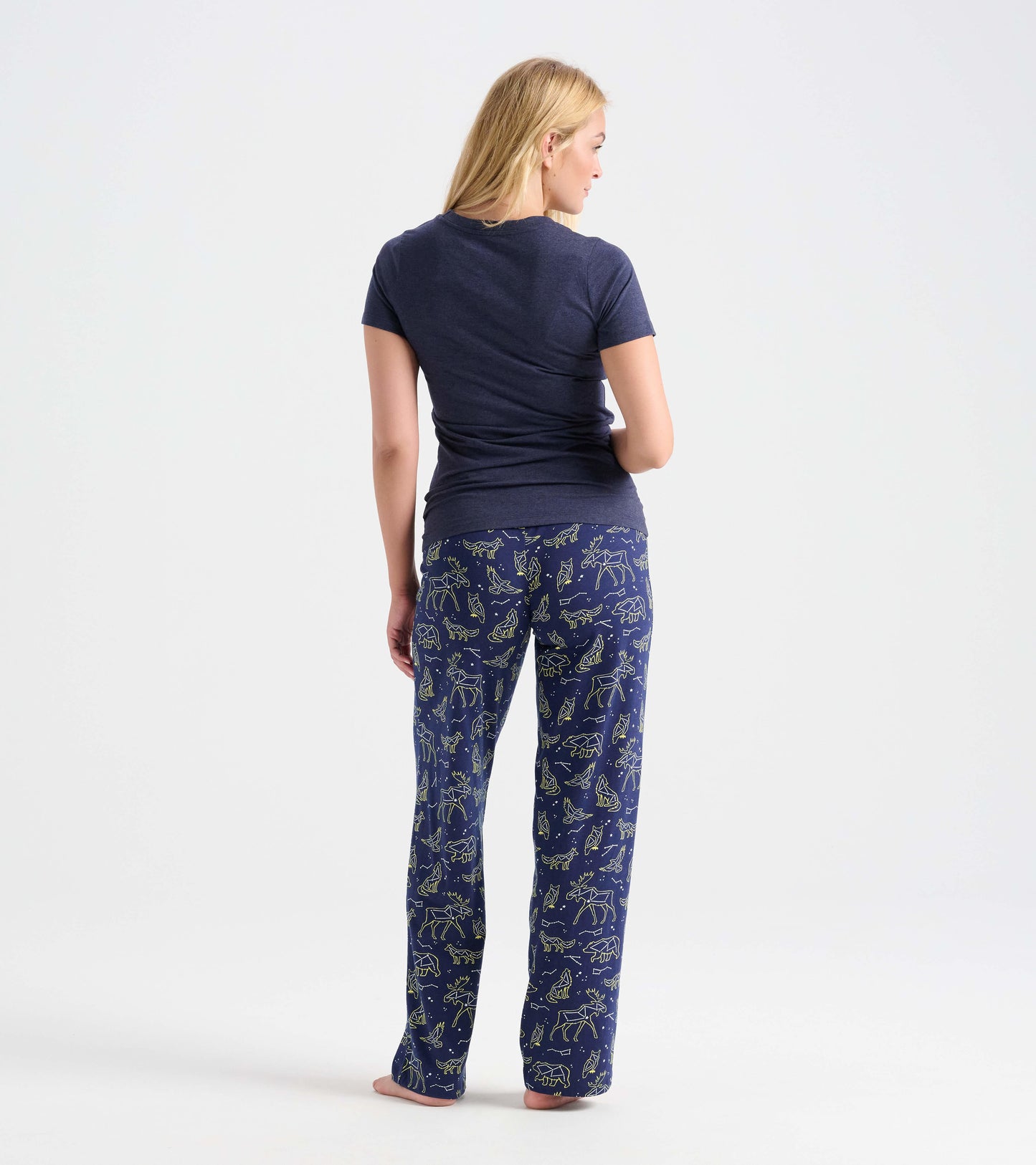 Navy cotton pajama pants featuring animal constellations in yellow, shown from the back with a fitted top.