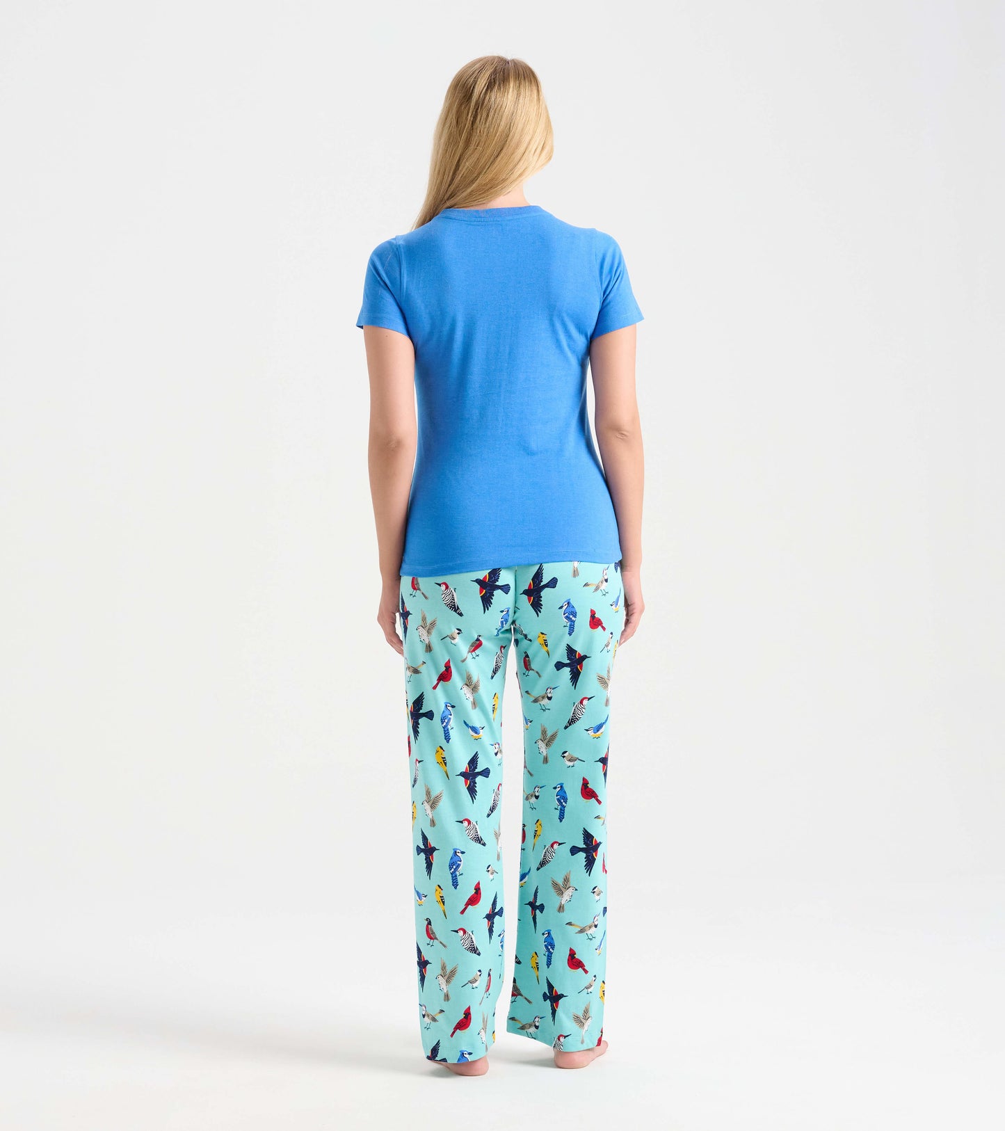 Blue short-sleeve pajama t-shirt paired with light blue pants featuring colorful bird patterns, viewed from the back.