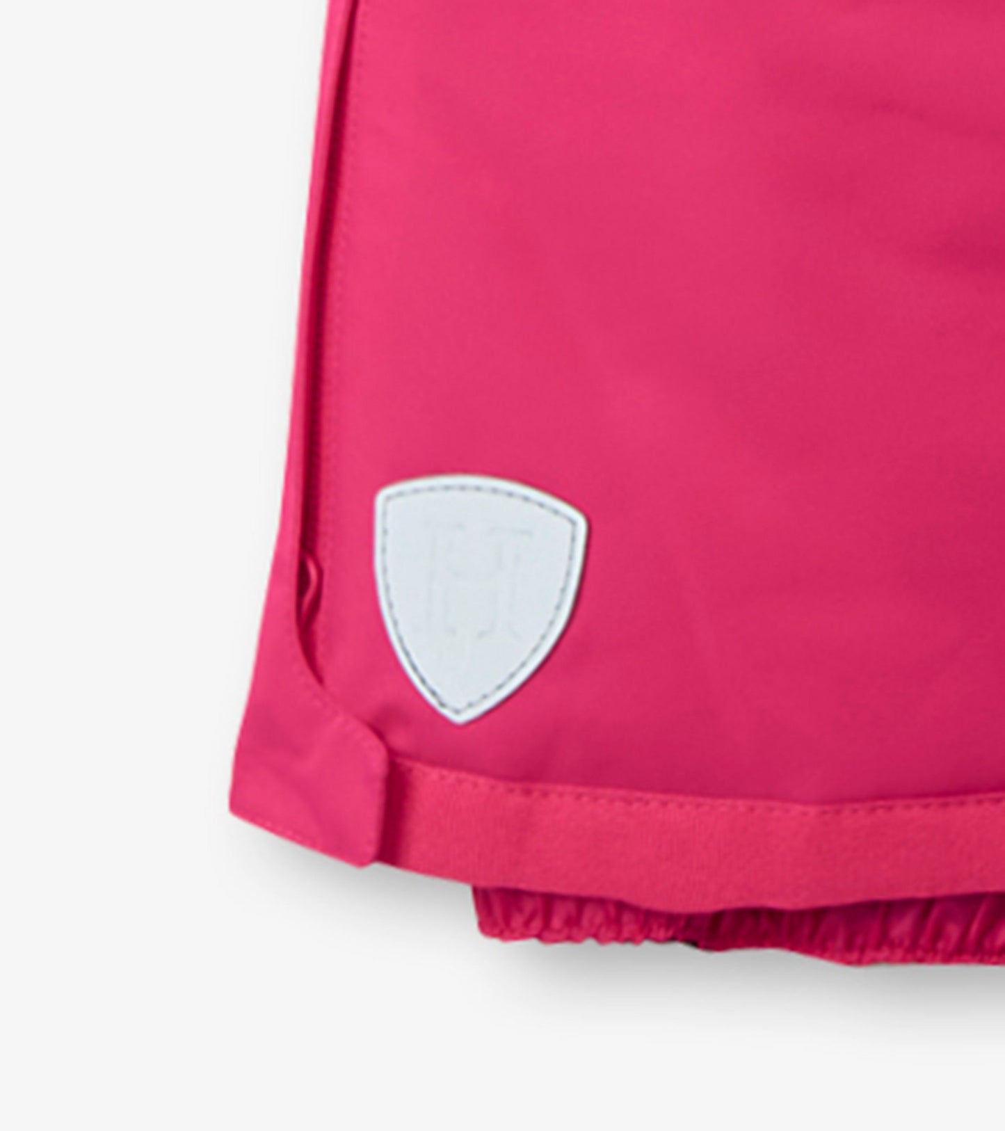 Bright pink kids' snow pants with elastic cuffs and a white logo patch on the side. Suitable for winter activities.