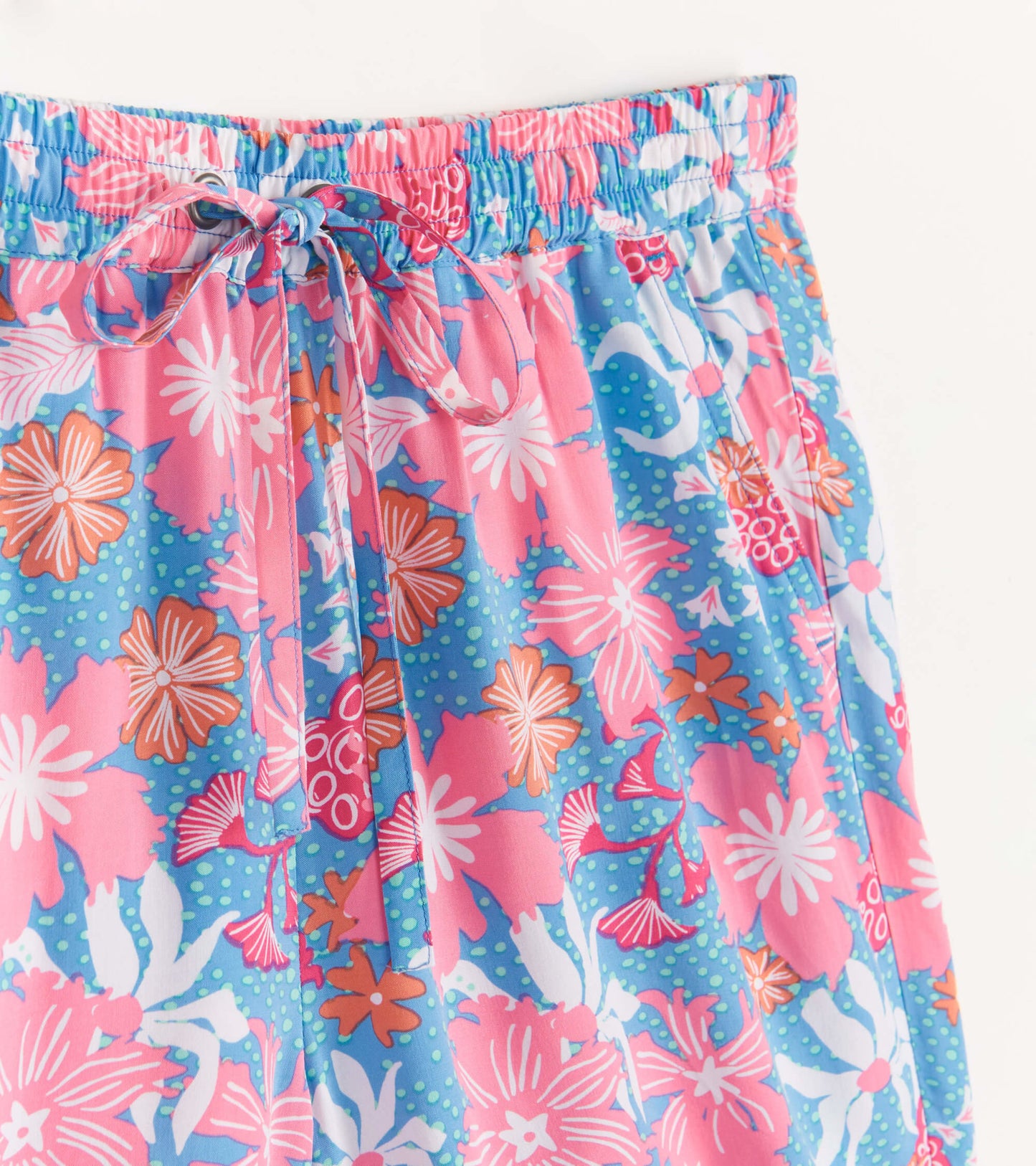 Colorful floral print shorts featuring a pink, blue, and white pattern with an elastic waistband and drawstring.