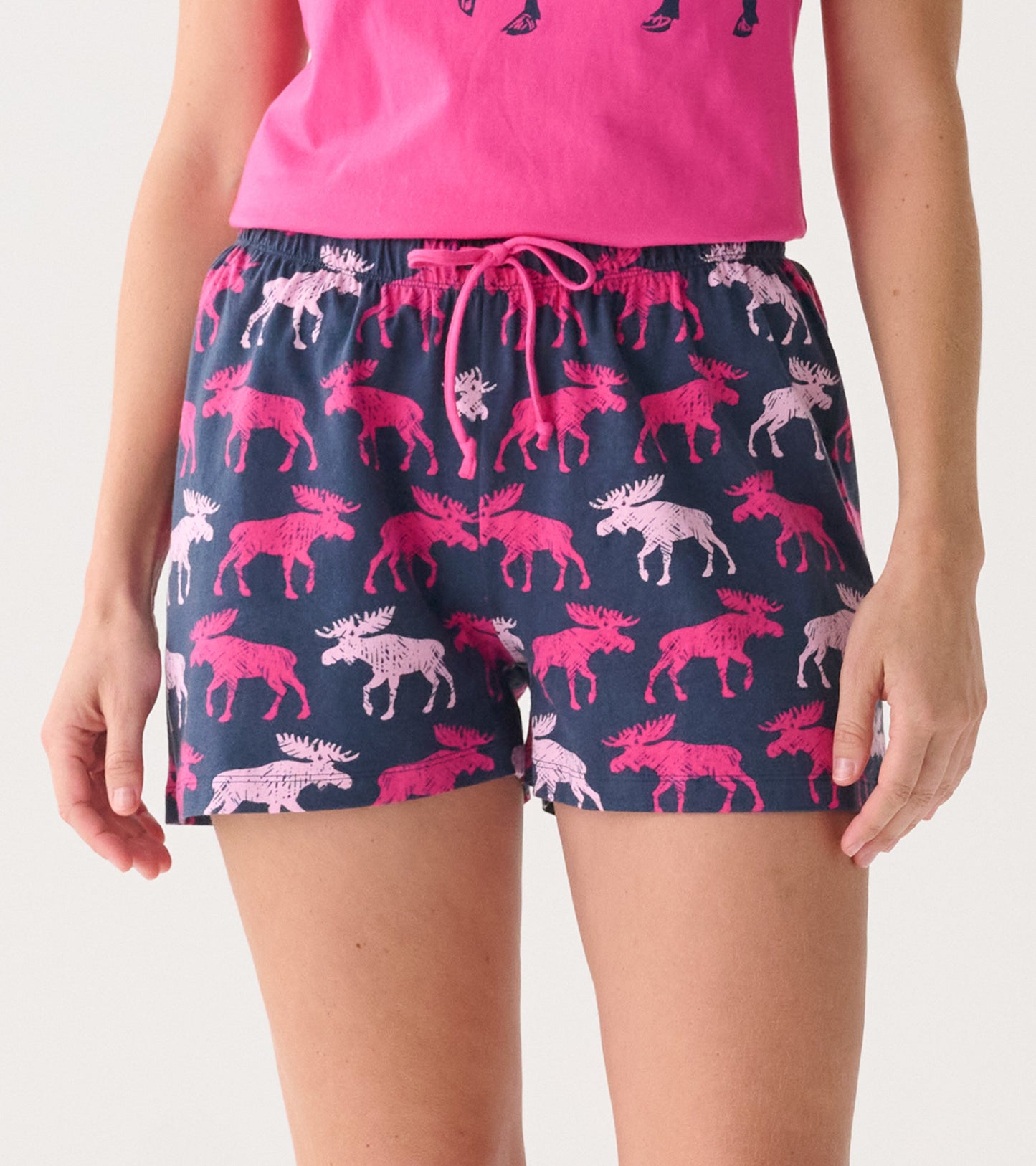 Navy cotton sleep shorts featuring a playful moose pattern in pink and white, with an elastic waistband and drawstring.