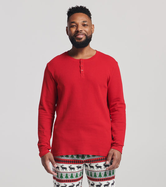 Red waffle henley shirt with long sleeves and a buttoned neckline, worn with festive patterned pants.