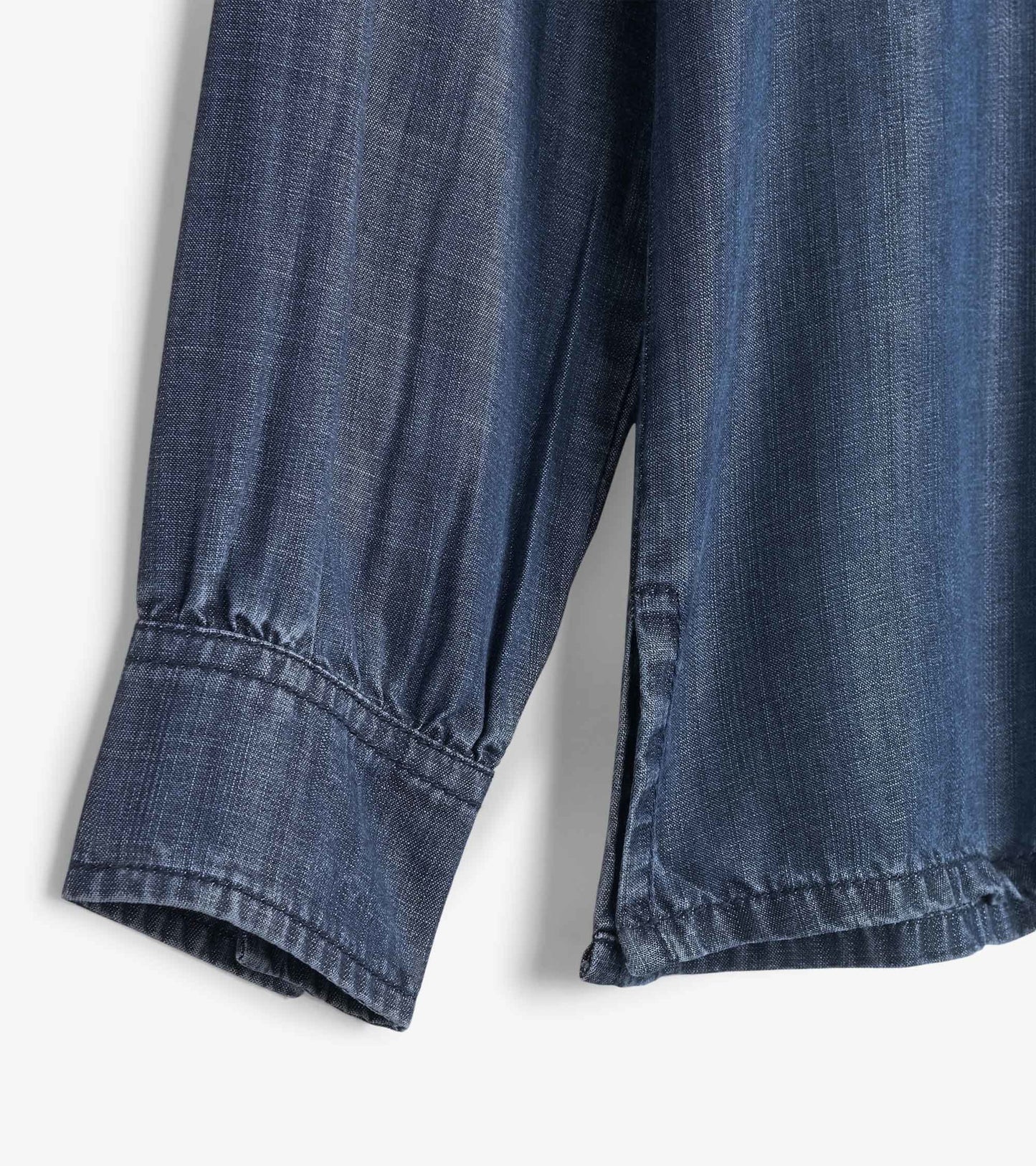 Maritime denim button-down shirt with long sleeves and gathered cuffs, showcasing a textured blue fabric.
