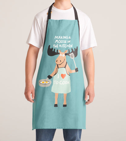 Turquoise apron featuring a cartoon moose holding a spatula and frying pan with eggs, text reads "Making a Moose In The Kitc…