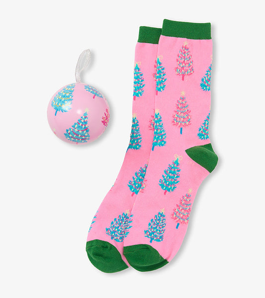 Pink crew socks with teal and pink Christmas trees, green cuffs and toes, beside matching ornament ball
