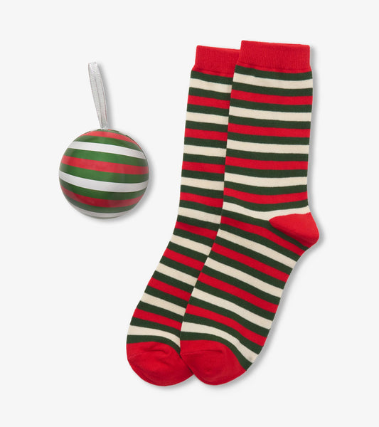 Pair of women's holiday socks with red, green and cream stripes beside a matching striped ornament ball
