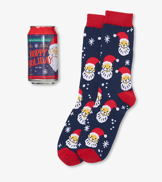 Navy men's socks with Santa faces and white snowflakes beside a red Hoppy Holiday beer can package