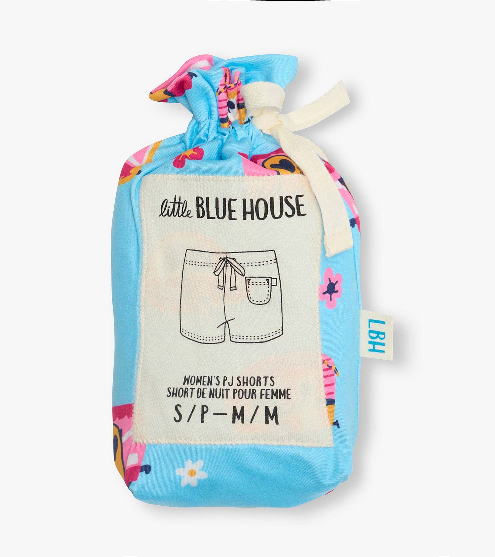 Folded blue pajama shorts with colorful retro camper and floral print, tied with cream ribbon, in a fabric pouch