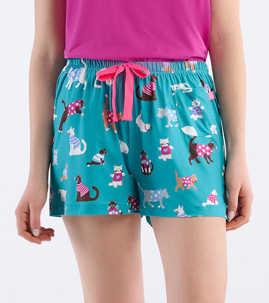 Close-up of teal pajama shorts with cat print, pink drawstring waist, and small front pocket