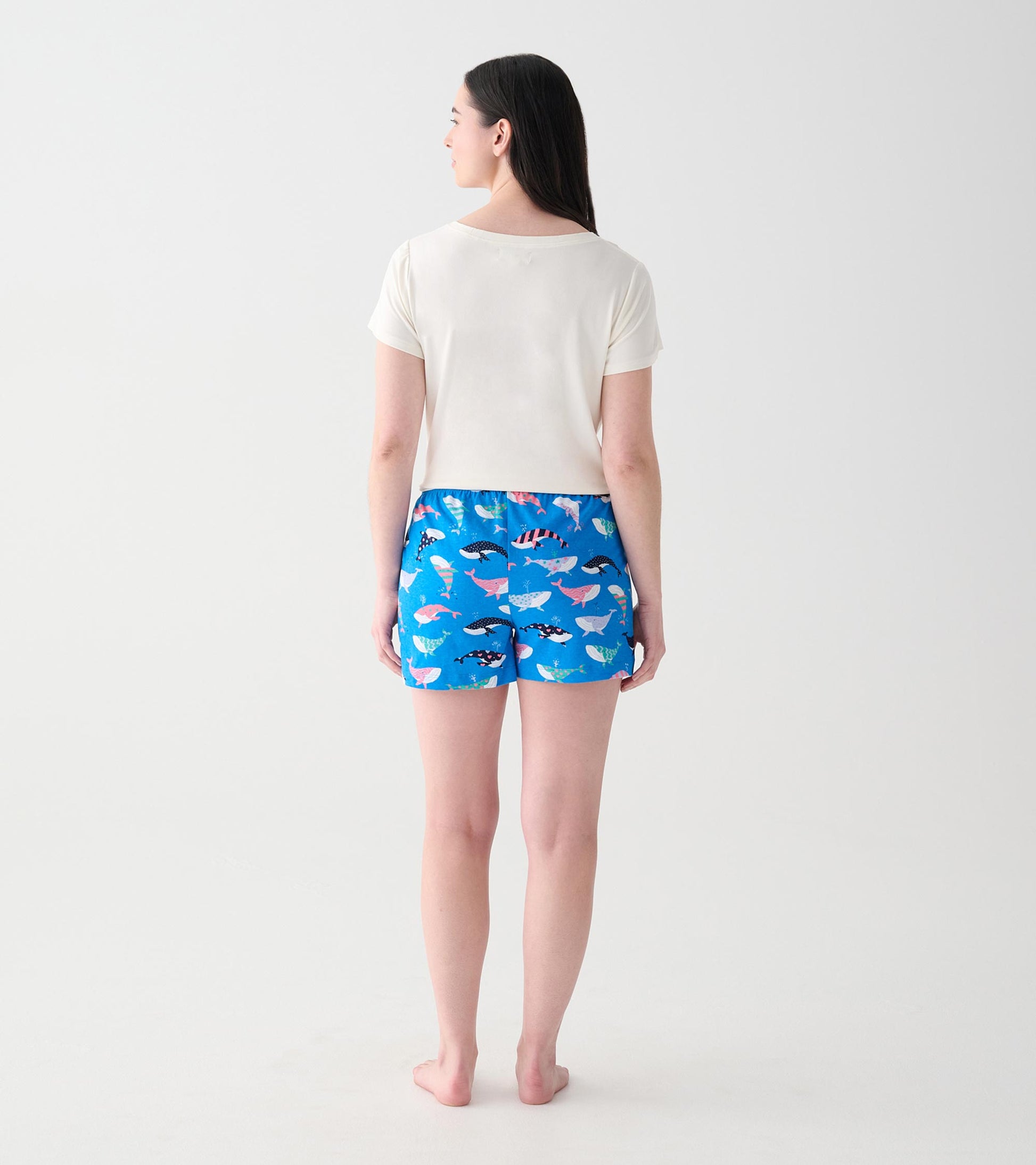 Back view of model wearing blue boxers with multicolored whale print