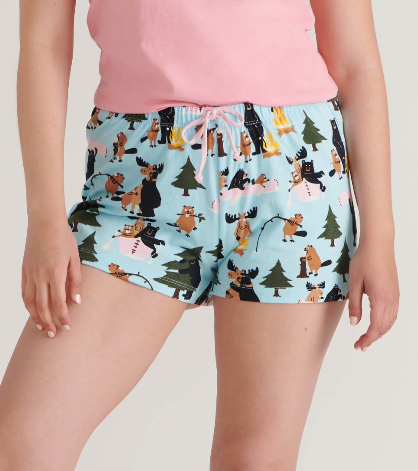 Close-up front view of blue sleep shorts with pink drawstring and woodland animal print