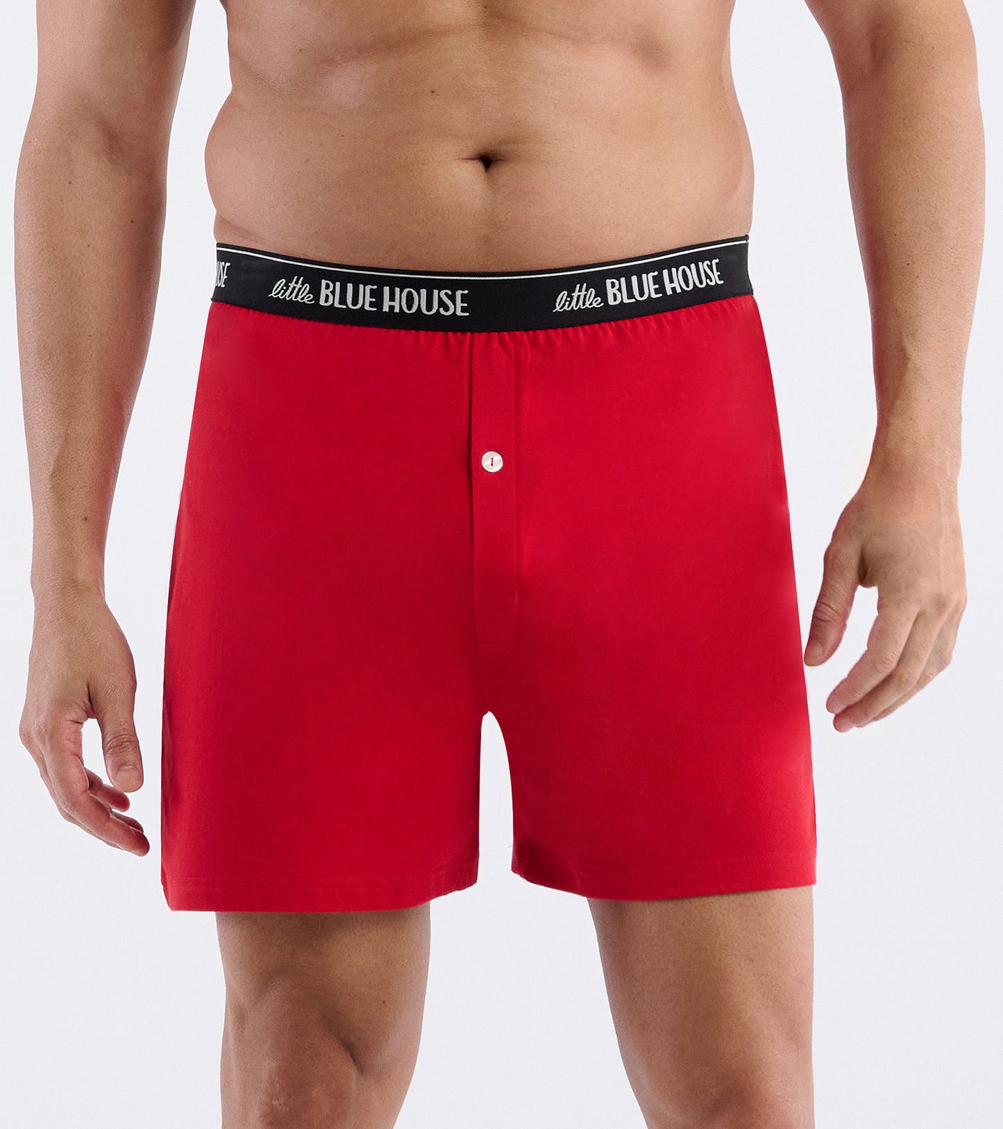 Red boxer shorts with black logo waistband and button fly, front view on a male model.