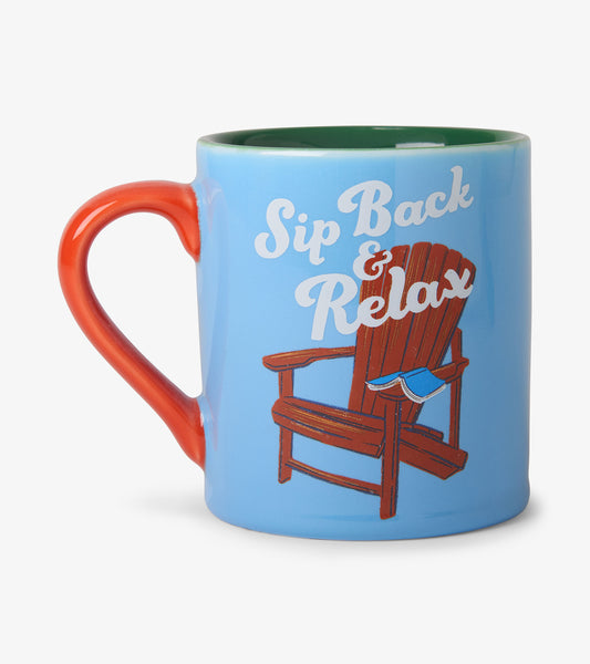 Blue ceramic mug with red handle and green rim, featuring a lounge chair and “Sip Back & Relax” text