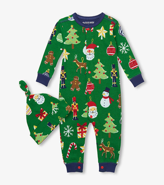 Front view of green baby Christmas sleeper and knotted hat with Santa, snowmen, trees, reindeer and ornaments