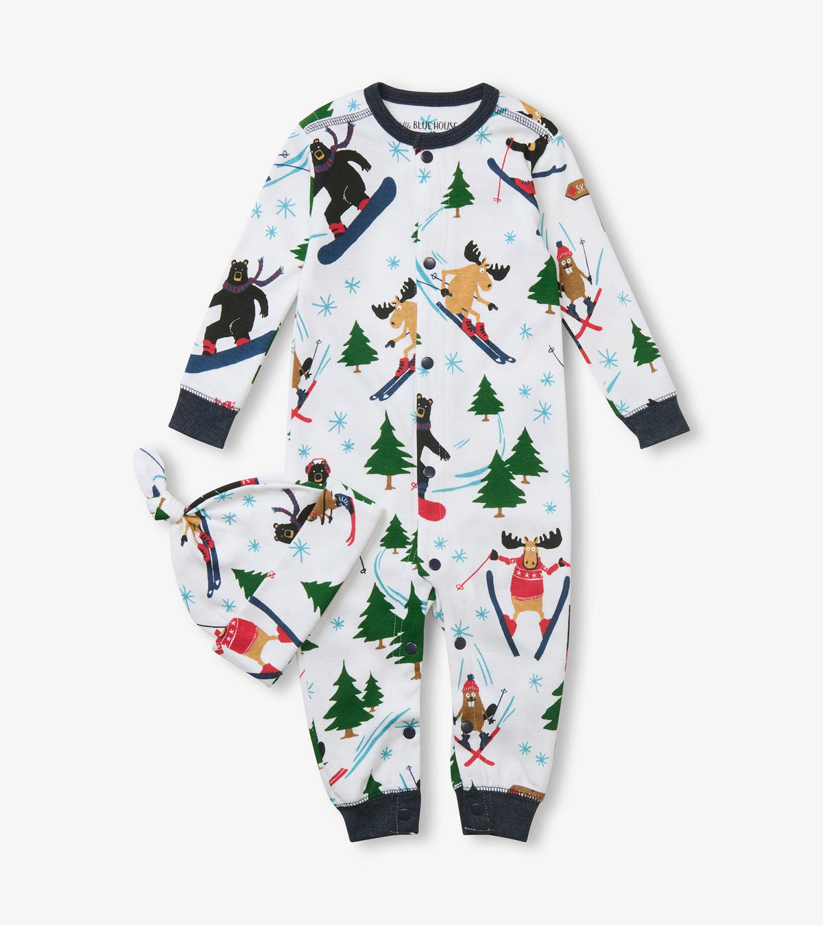 Front view of baby sleeper and knotted hat with skiing animal and evergreen print on white