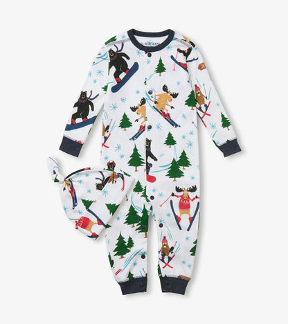 Front view of baby sleeper and knotted hat with skiing animal and evergreen print on white