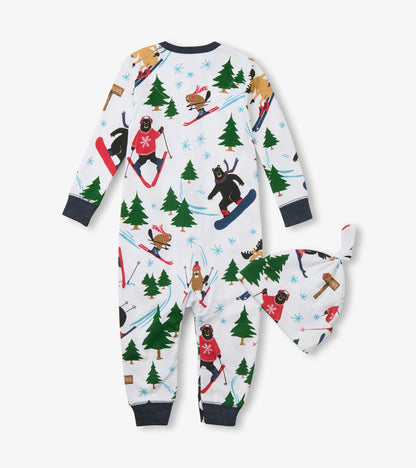 Back view of baby sleeper and knotted hat with skiing animal and evergreen print on white