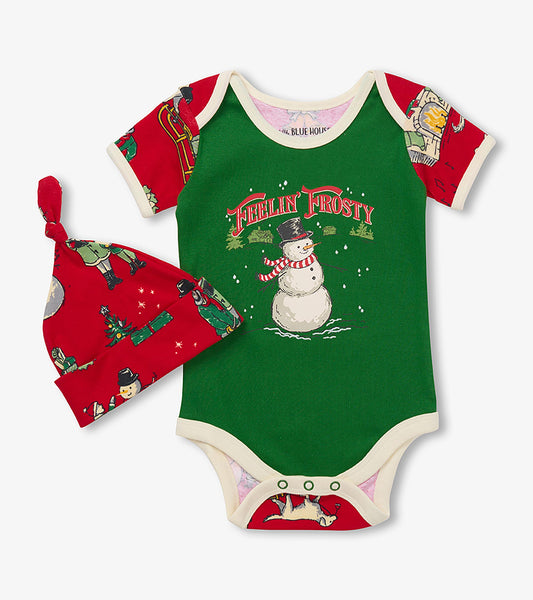 Front of baby Christmas bodysuit and hat set with green snowman graphic and red vintage holiday print