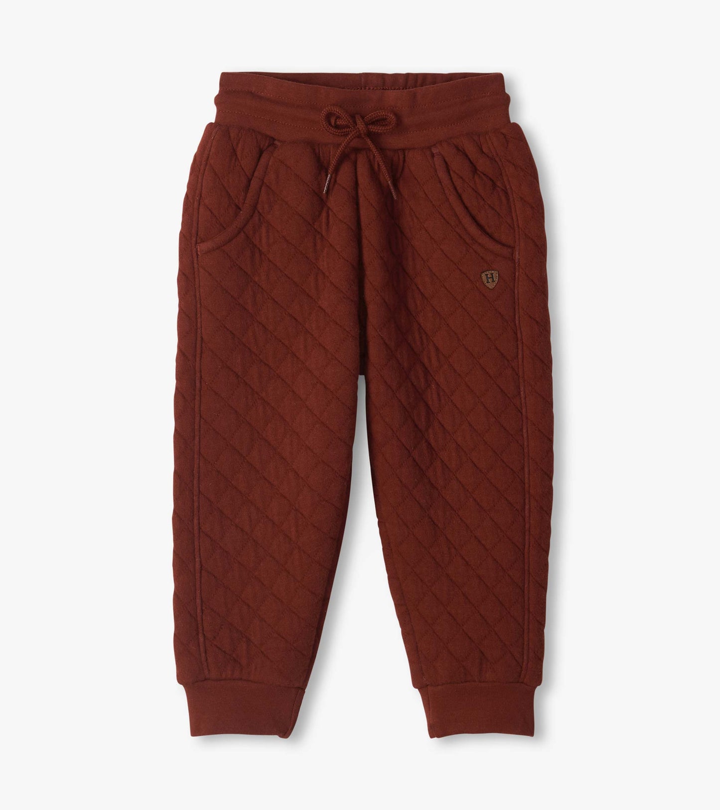 Madder brown quilted jogger pants with diagonal stitching, drawstring waist, side pockets, and cuffed ankles