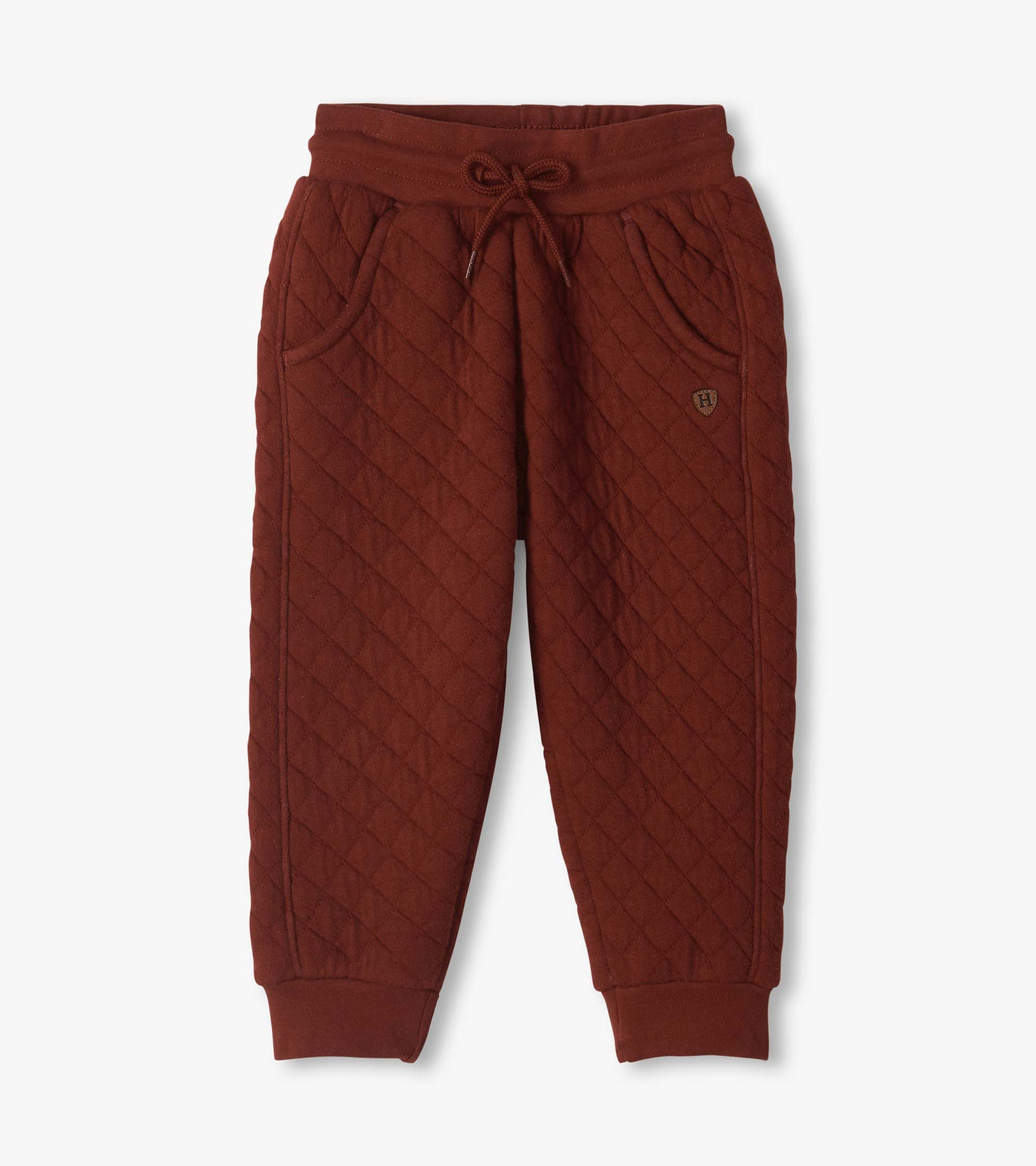 Madder brown quilted jogger pants with diagonal stitching, drawstring waist, side pockets, and cuffed ankles