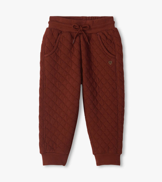Madder brown quilted jogger pants with diagonal stitching, drawstring waist, side pockets, and cuffed ankles