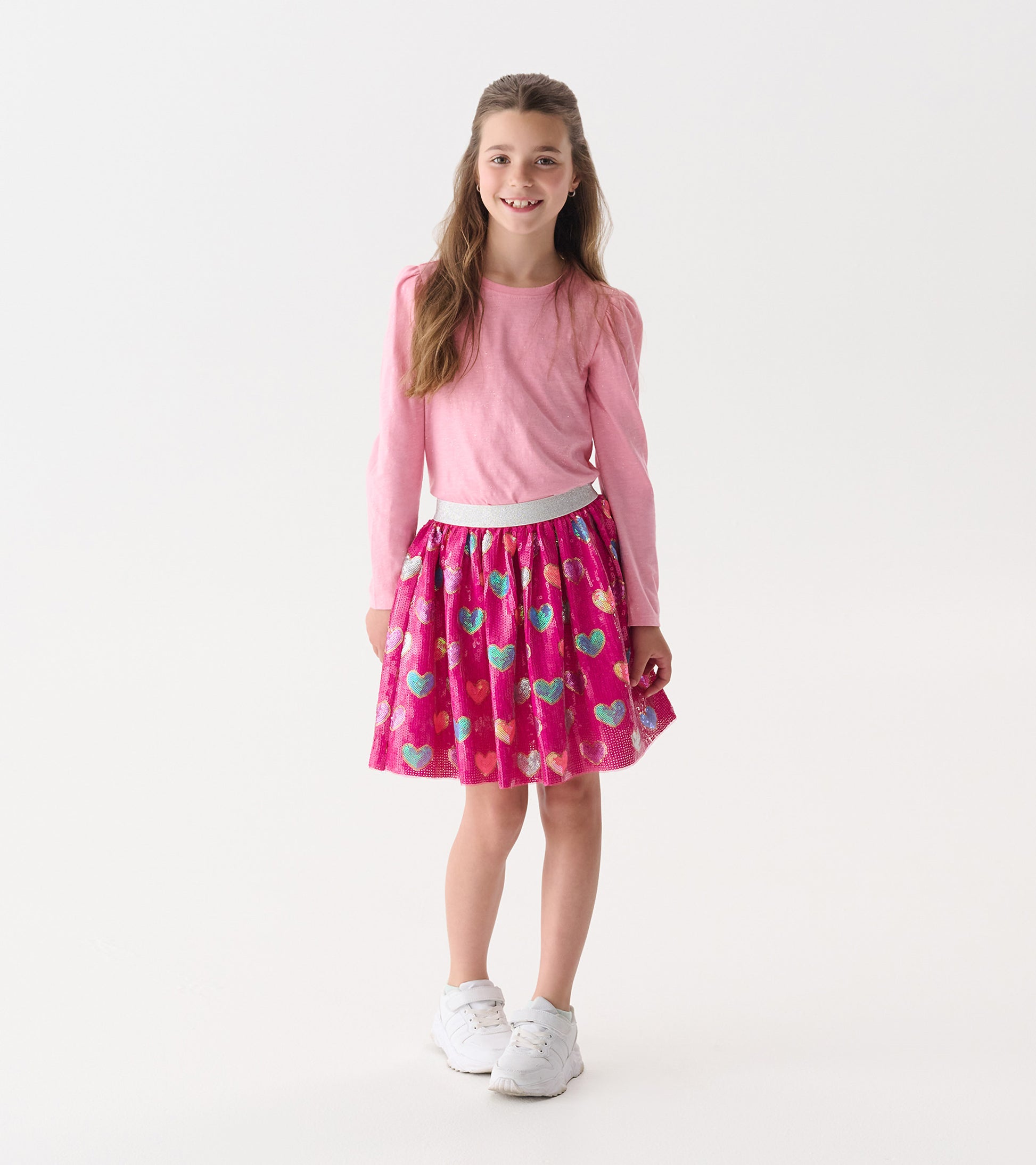 Pink puff sleeve graphic tee paired with a vibrant heart-patterned skirt, perfect for casual wear.