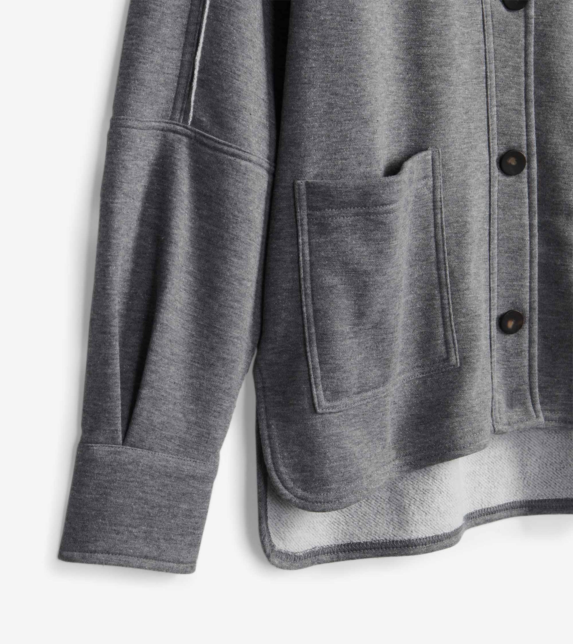 Charcoal melange blazer detail with front patch pocket, black buttons, sleeve seam, and turned-up hem
