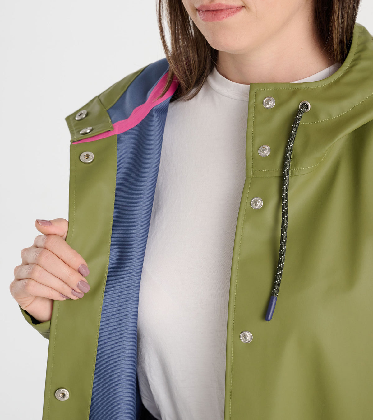 Close-up of loden green rain jacket with snap front, drawcord hood, and blue lining with pink trim