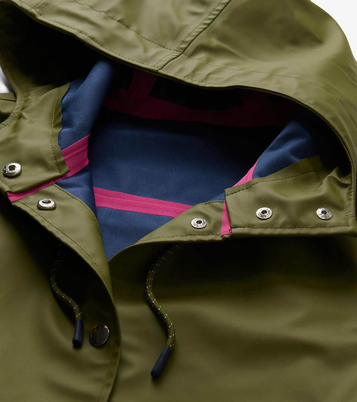 Hood interior close-up of loden green rain jacket with blue lining, pink trim, and snap placket