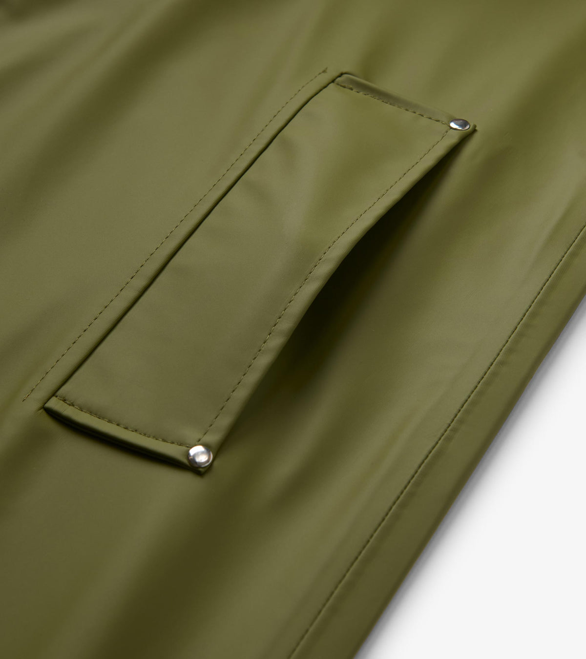 Close-up of loden green rain jacket flap pocket with silver rivet corners