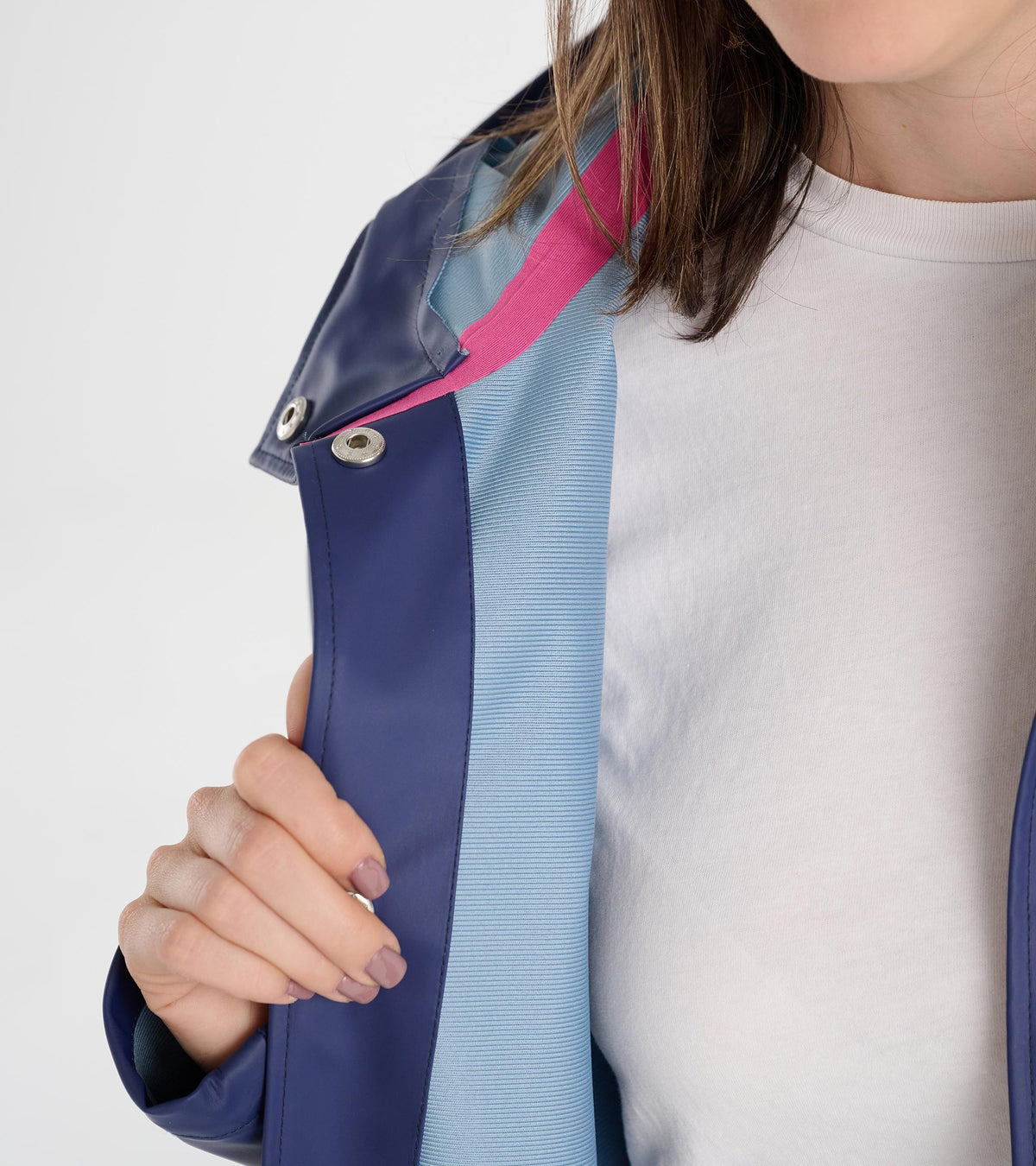 Close-up of patriot blue rain jacket opening with light blue lining, pink seam trim, and silver snaps