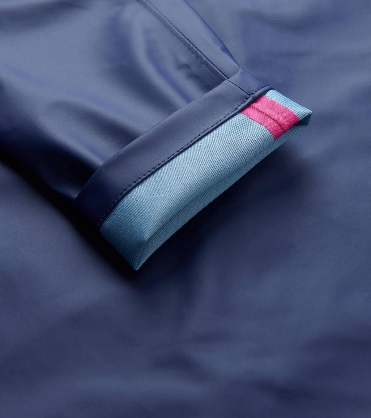 Close-up of the patriot blue rain jacket cuff with light blue knit trim and a pink stripe.