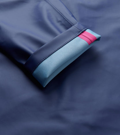 Close-up of the patriot blue rain jacket cuff with light blue knit trim and a pink stripe.