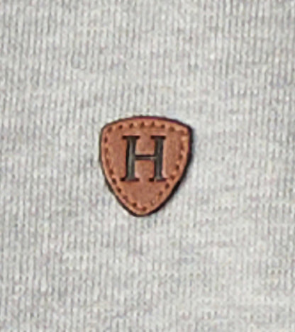 Grey zip-up hoodie featuring a textured fabric and a brown leather patch with an embossed letter "H.
