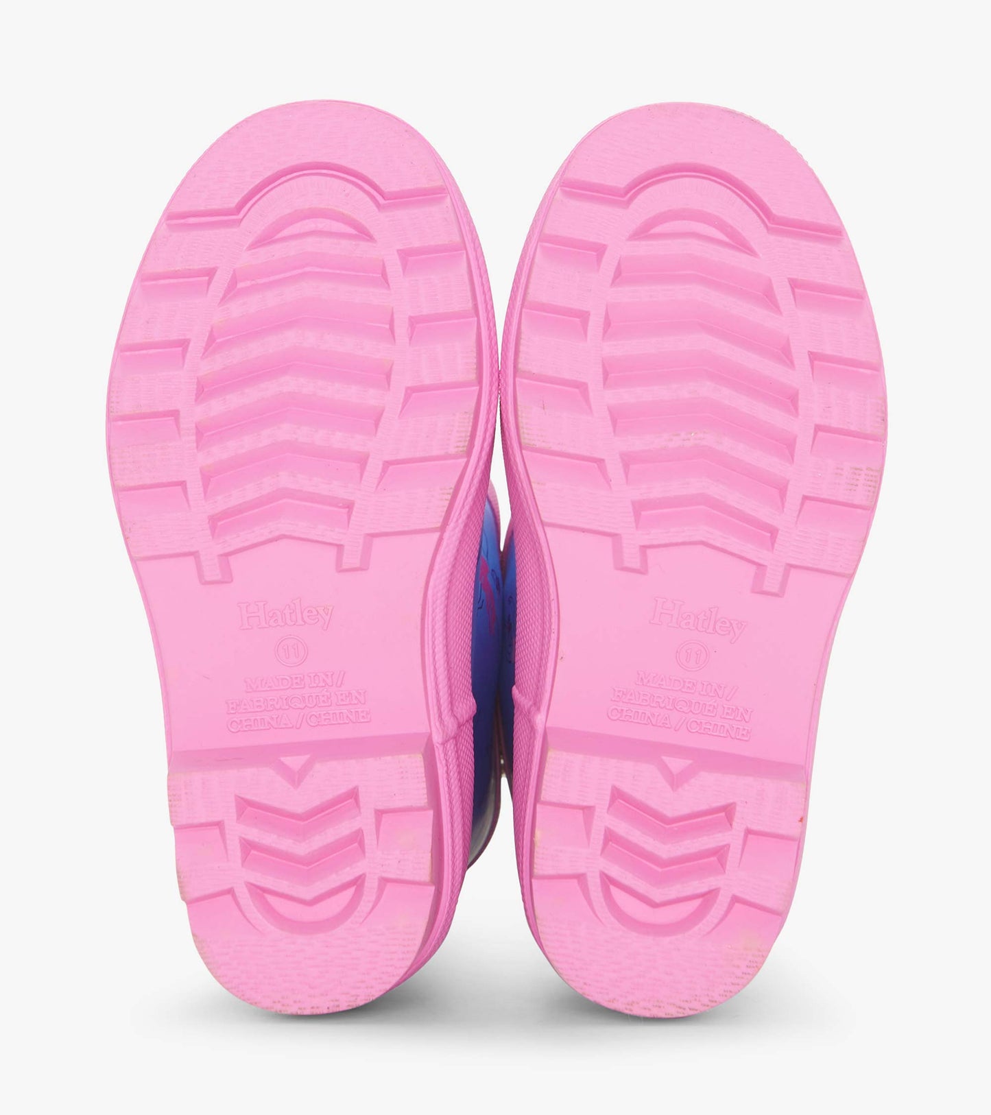 Pink rubber soles of girls' ballet school matte rain boots with textured grip pattern.