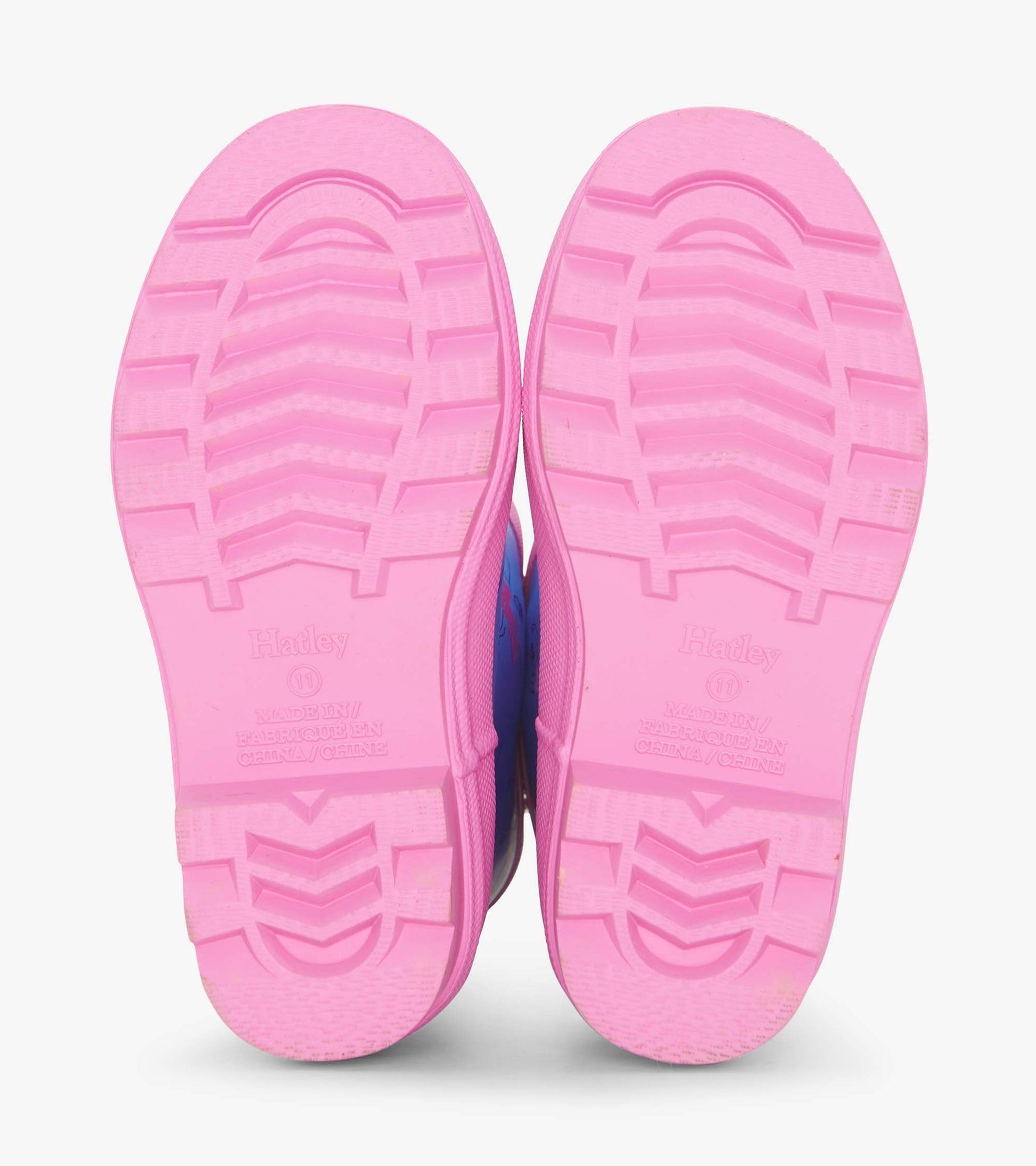 Pink rubber soles of girls' ballet school matte rain boots with textured grip pattern.