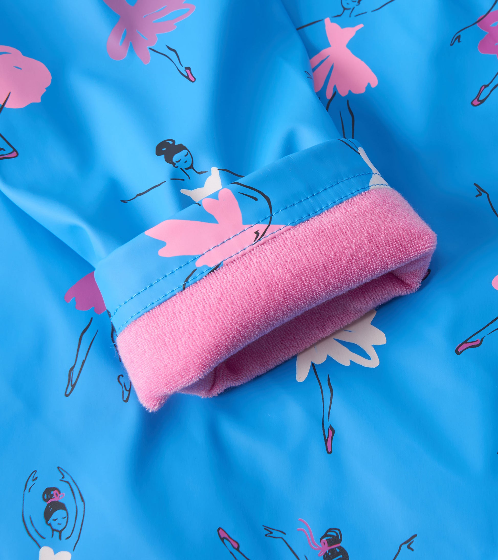 Blue rain jacket featuring ballet dancer prints, with a pink fleece-lined cuff for added comfort.