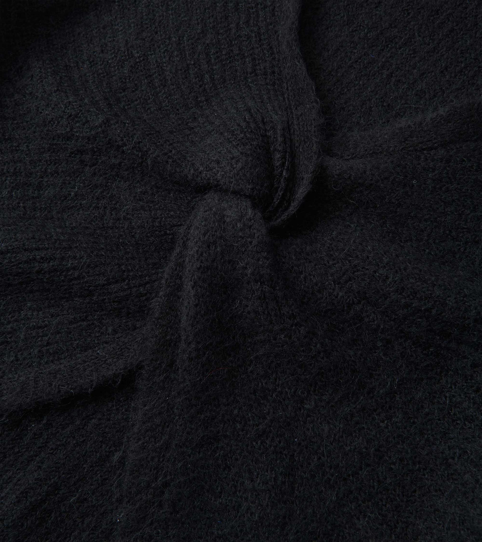 Black cross over sweater with a textured knit pattern, showcasing a soft and cozy fabric.