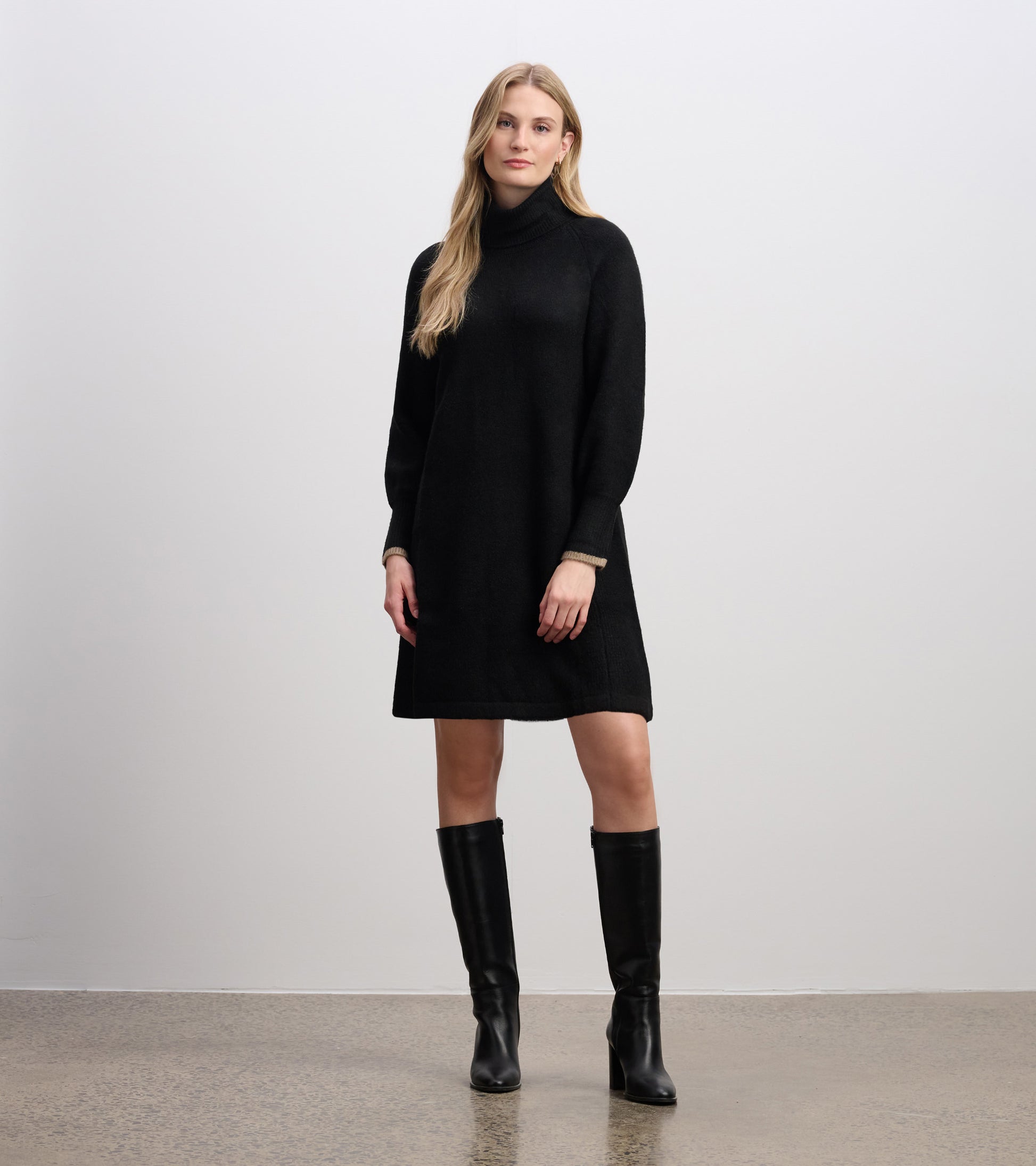 Black long-sleeve turtleneck sweater dress with a relaxed fit and beige cuff trim, front view