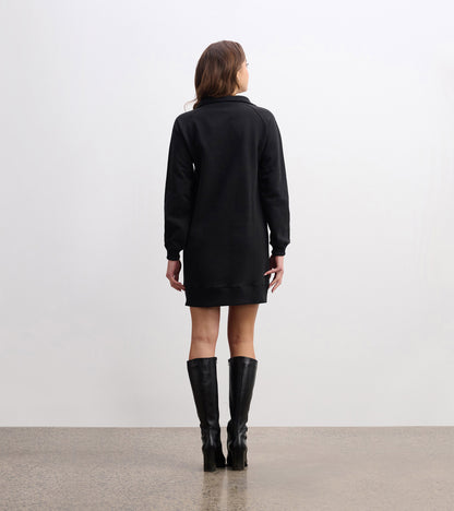 Black notch neck dress with long sleeves, knee-length, and a relaxed fit, styled with knee-high black boots.