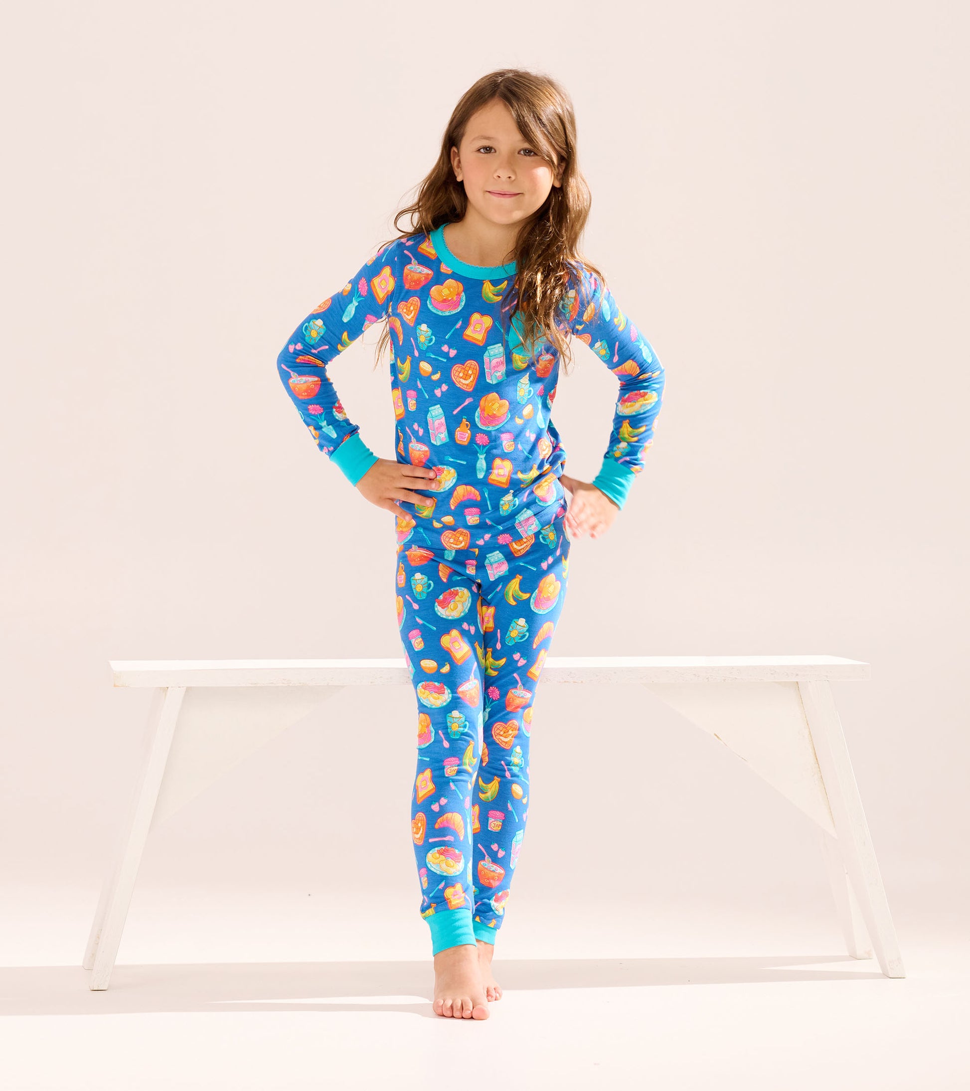 Blue bamboo pajama set for girls featuring colorful breakfast food patterns, long sleeves, and fitted pants.