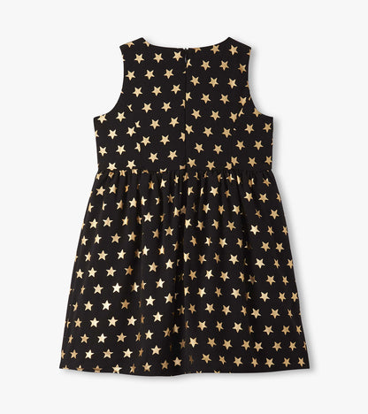 Black sleeveless dress featuring a gold star pattern, with a gathered skirt for a playful look.