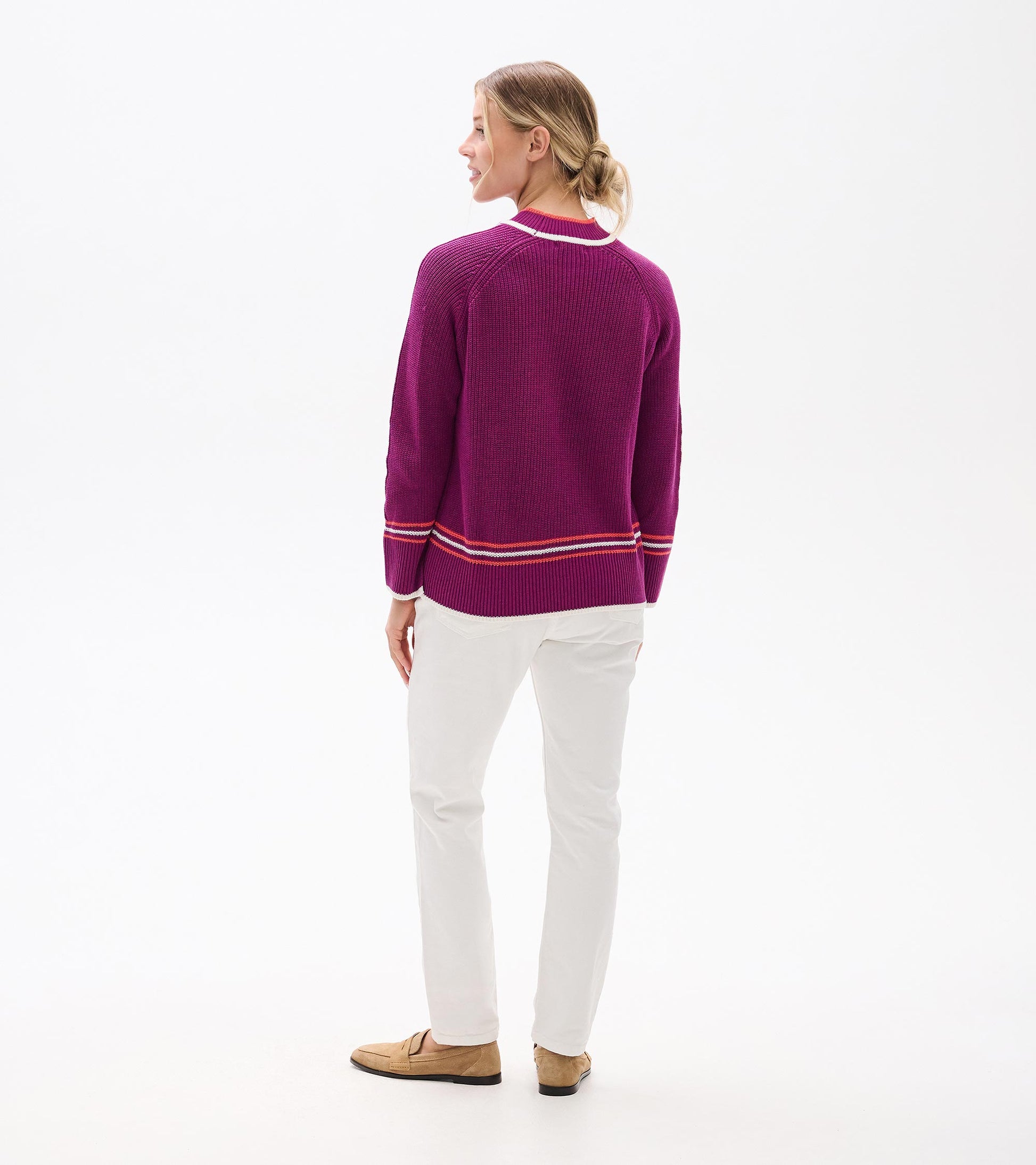 Raglan pullover in crushed grape with striped hem, worn with white pants, viewed from the back.
