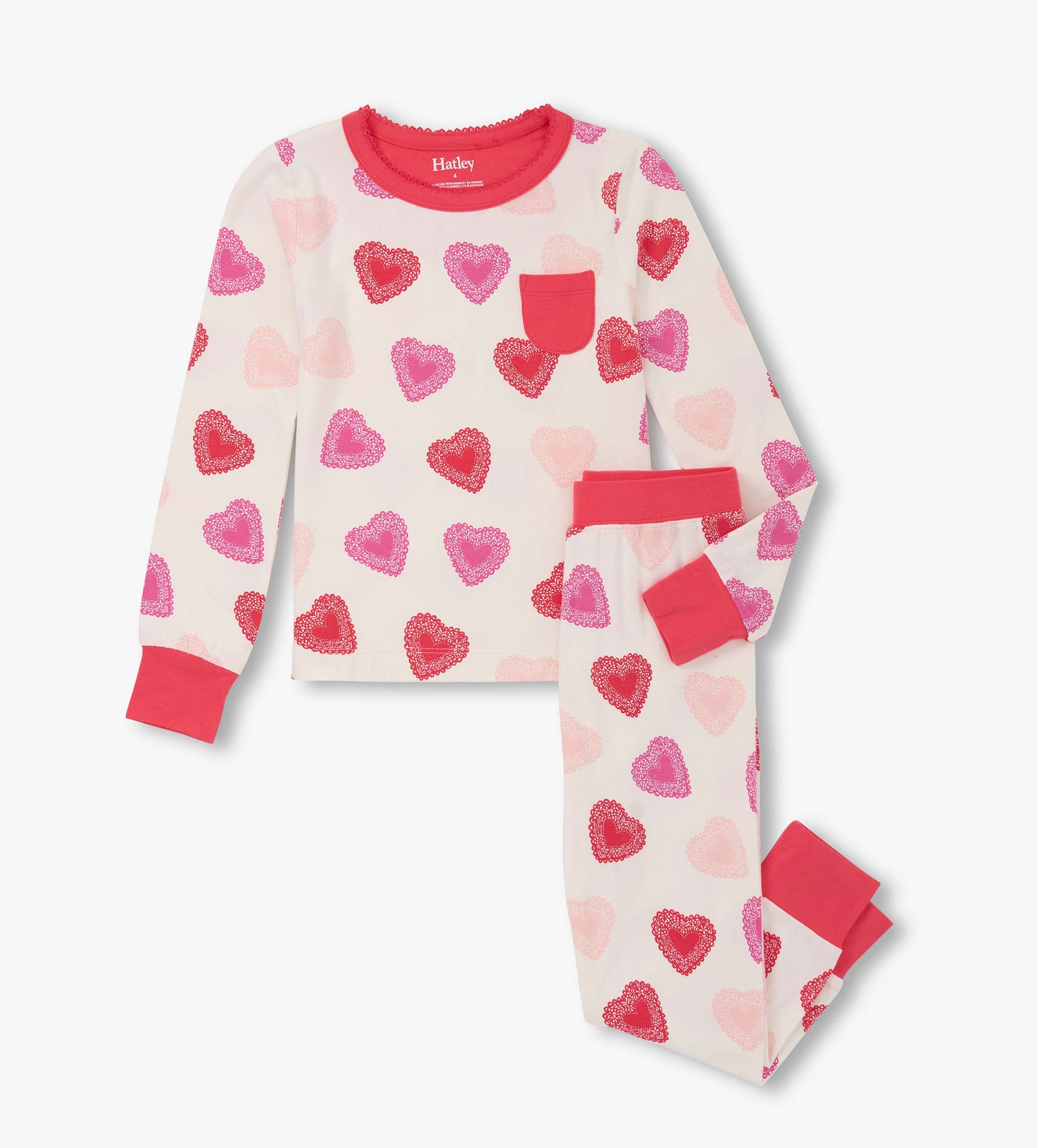 Long-sleeve pajama set featuring a cream background with colorful heart patterns and contrasting red cuffs and pocket.