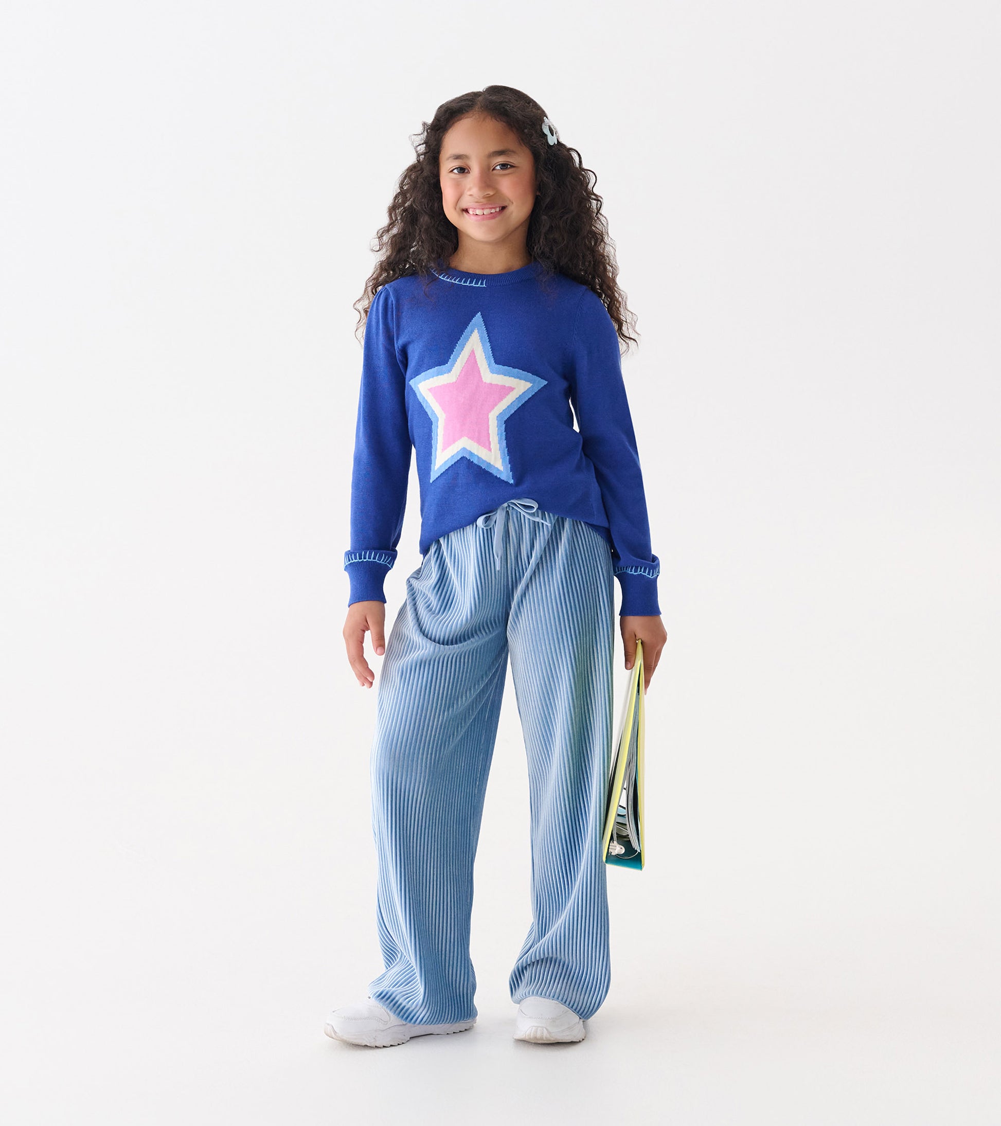 Blue pullover sweater featuring a large pink star design, paired with light blue striped pants.