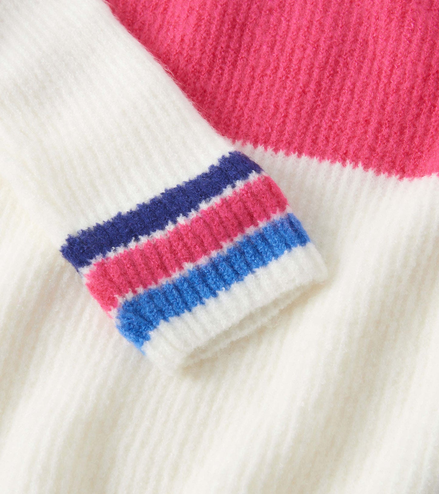 Colourblock mockneck sweater featuring white, pink, and multicolored striped cuffs in a soft knit material.