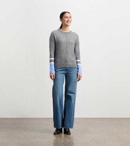 Charcoal melange sweater with purple and blue striped sleeves, round neckline, and relaxed fit, worn with wide-leg jeans.