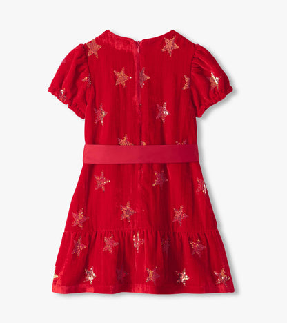 Back view of red dress with puff sleeves, star sequins, back zipper, and tiered skirt